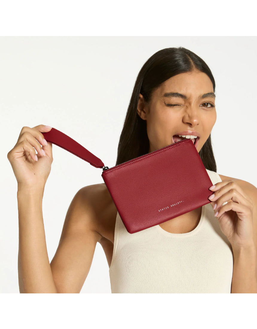 Status Anxiety Take Your Chances Wallet in rouge color, featuring a compact leather design with multiple card slots and a sleek finish.
