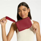 Status Anxiety Take Your Chances Wallet in rouge, featuring a compact leather design with multiple card slots and a sleek finish.