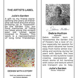 The Artists Label Julie’s Garden scarf draped on a hanger, showcasing vibrant floral patterns and lightweight fabric.