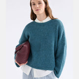 Elk Agna Sweater in stone blue, soft knit fabric, displayed on a hanger, showcasing its cozy, casual clothing style.