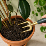 Green We The Wild hand fork garden tool with a sturdy handle and tines, ideal for planting and cultivating in the garden.