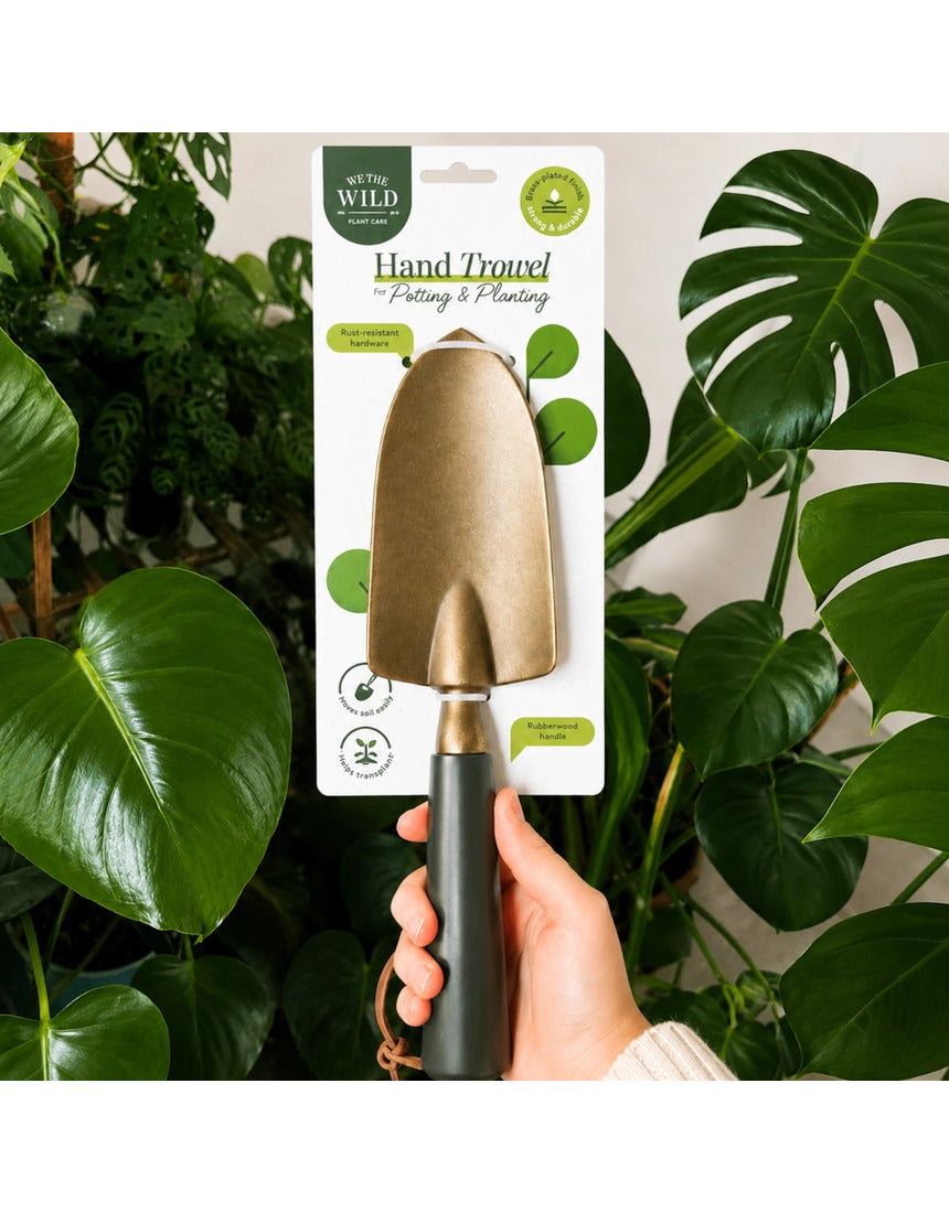 Green We The Wild hand trowel, a garden tool with a sturdy metal blade and ergonomic handle for planting and digging.