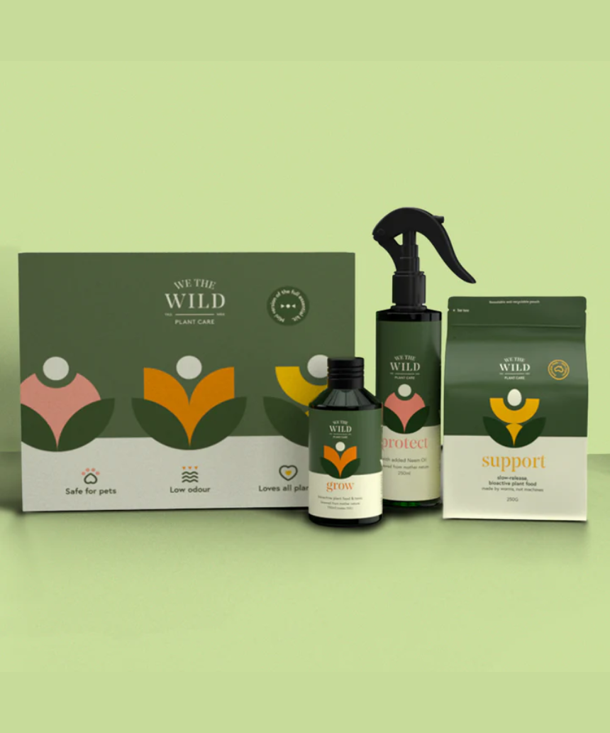 We The Wild Essential Plant Care Kit with various healthy, lush green plants in natural pots, perfect for plant care enthusiasts.