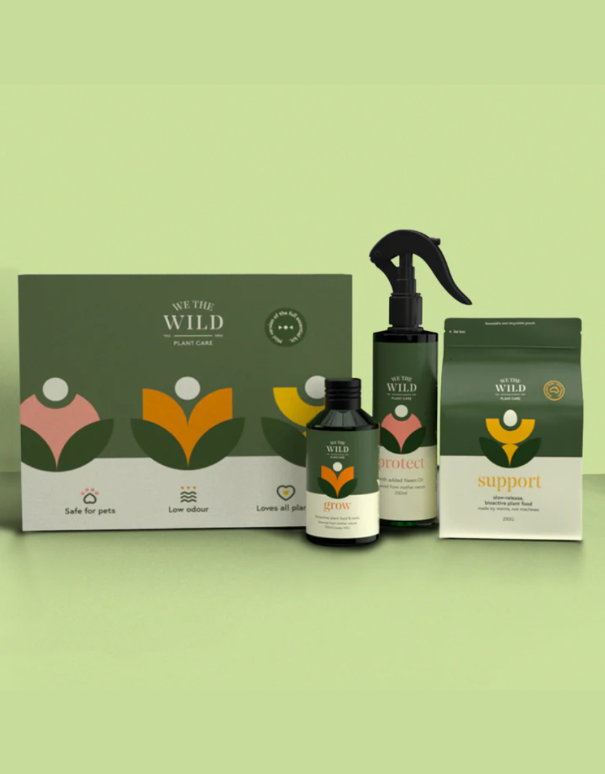 We The Wild Essential Plant Care Kit with various healthy, lush green plants in natural pots, perfect for plant care enthusiasts.