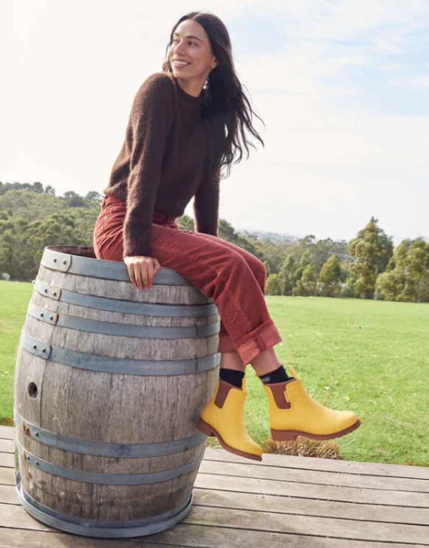 Bright yellow Merry People Bobbi gumboots with sunflower design, waterproof rubber rain boots for women.