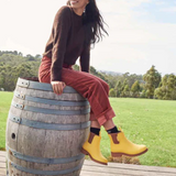 Bright yellow Merry People Bobbi gumboots with sunflower design, waterproof rubber rain boots for women.