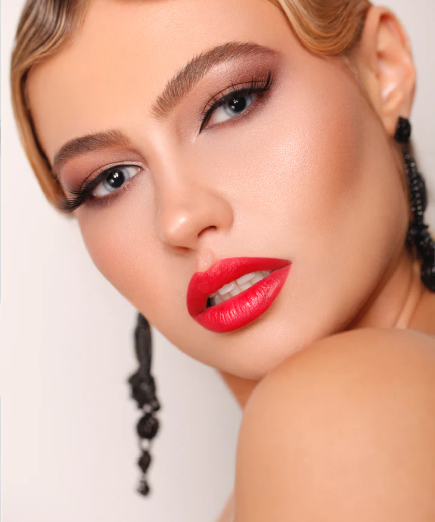 Suzy Lipsticks Poppy matte lipstick in sleek tube, vibrant coral-orange shade with a smooth, velvety finish.