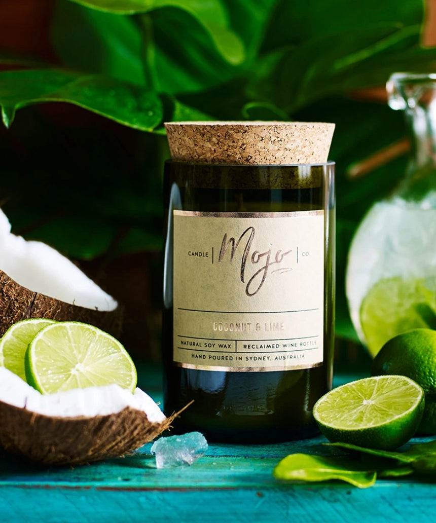 Scented candle from Mojo Candle Co. in coconut and lime fragrance with a sleek glass jar and label design.
