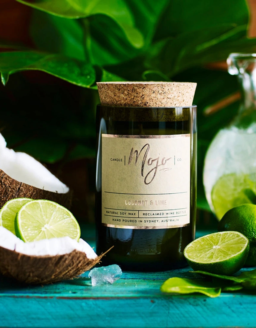 Scented candle from Mojo Candle Co. in coconut and lime fragrance with a sleek glass jar and label design.