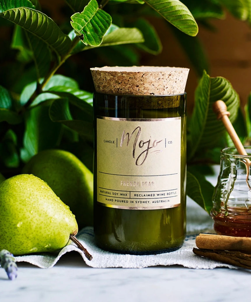 Mojo Candle Co. French Pear candle with a sleek jar and label, emitting a warm, inviting ambiance.