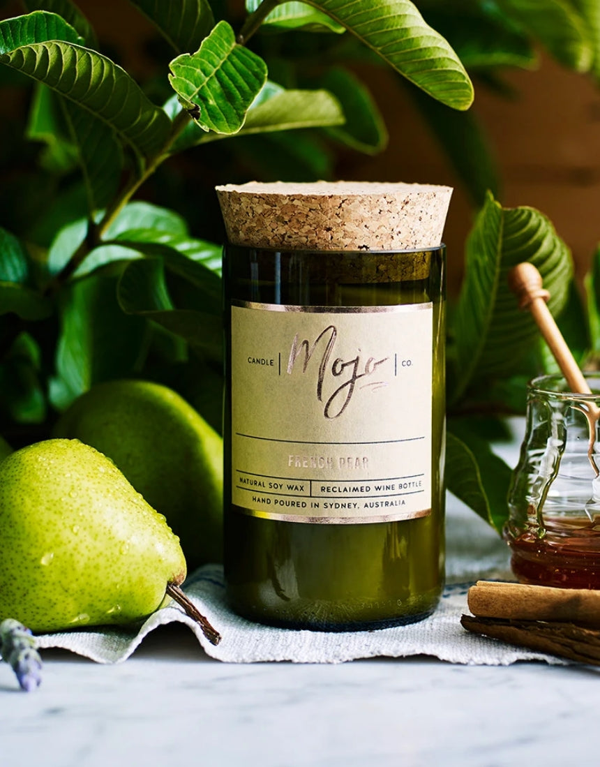 Mojo Candle Co. French Pear candle with a sleek jar and label, emitting a warm, inviting ambiance.