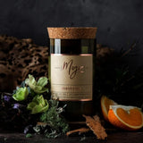 Mojo Candle Co. oakmoss and sage scented candle with a glass jar and wooden lid, showcasing natural botanical elements.
