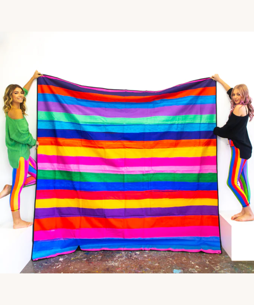 Riley Burnett picnic rug with colorful carnival stripe pattern, outdoor blanket for picnics and gatherings on grass or sand.