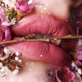 Suzy Lipsticks Miss Cassandra Peony matte lipstick, showing the deep pink shade in a sleek tube on a neutral background.